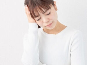 頭痛の女性の写真（不定愁訴・耳の症状イメージ）